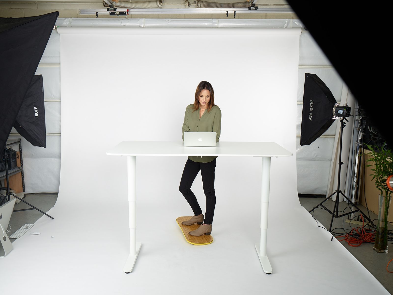 a woman standing at a table with a laptop