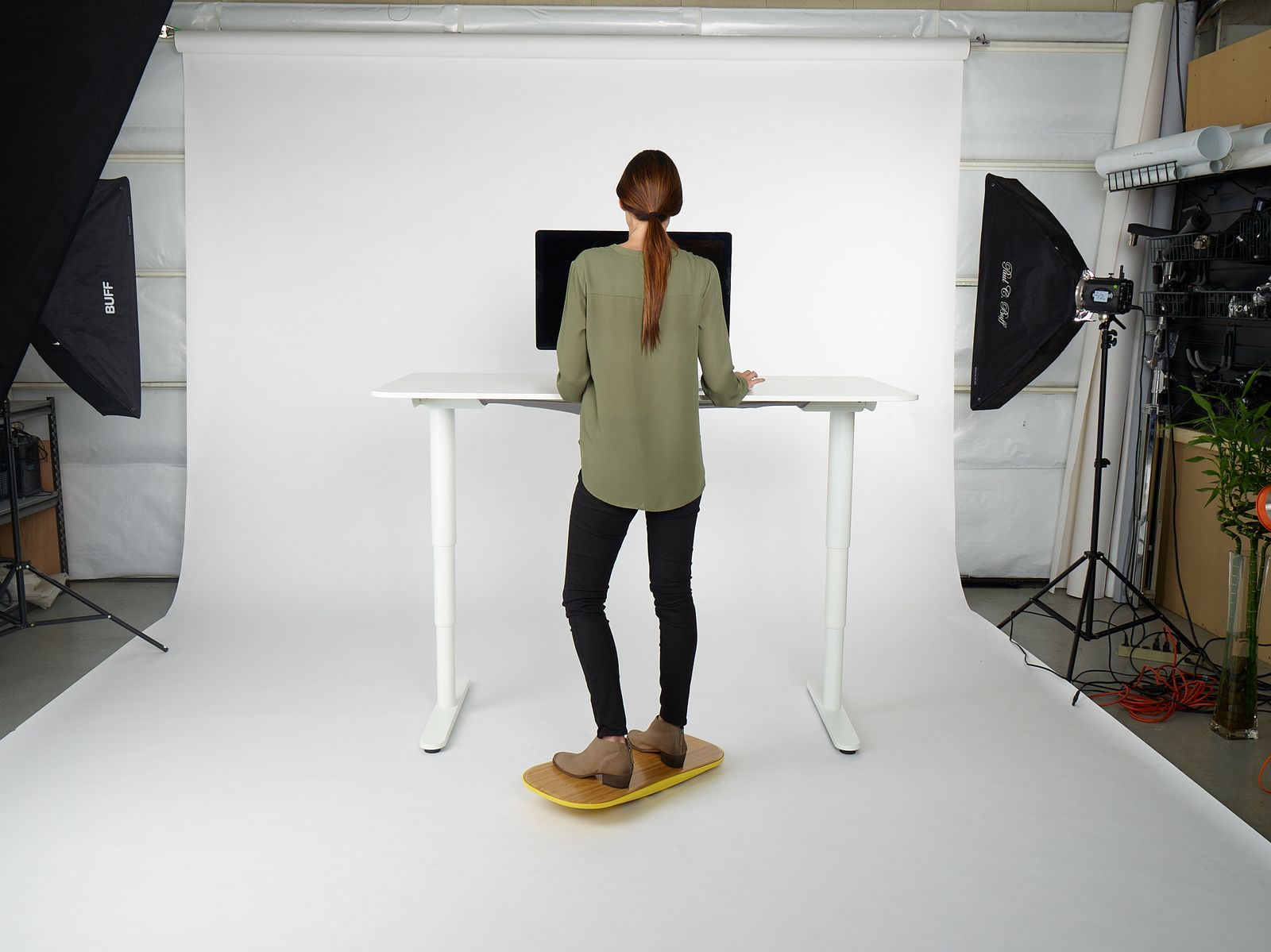 a woman standing at a desk in front of a camera