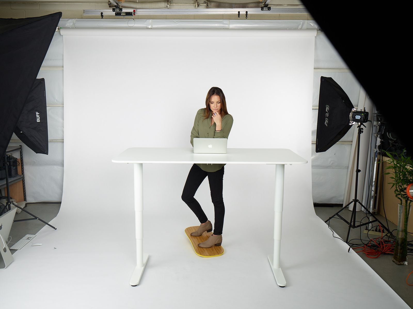 a woman standing at a table with a laptop