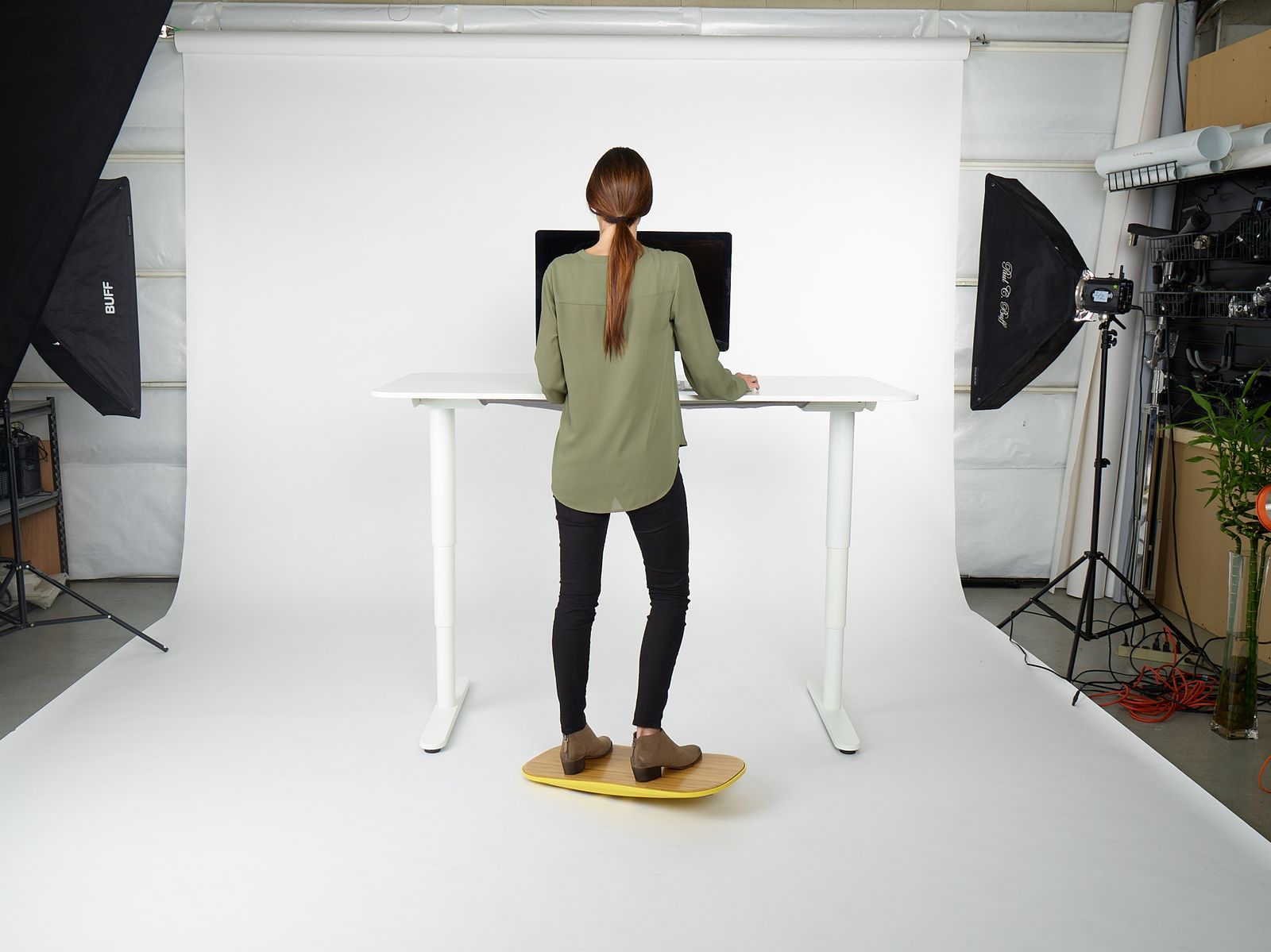 a woman standing at a desk in front of a camera