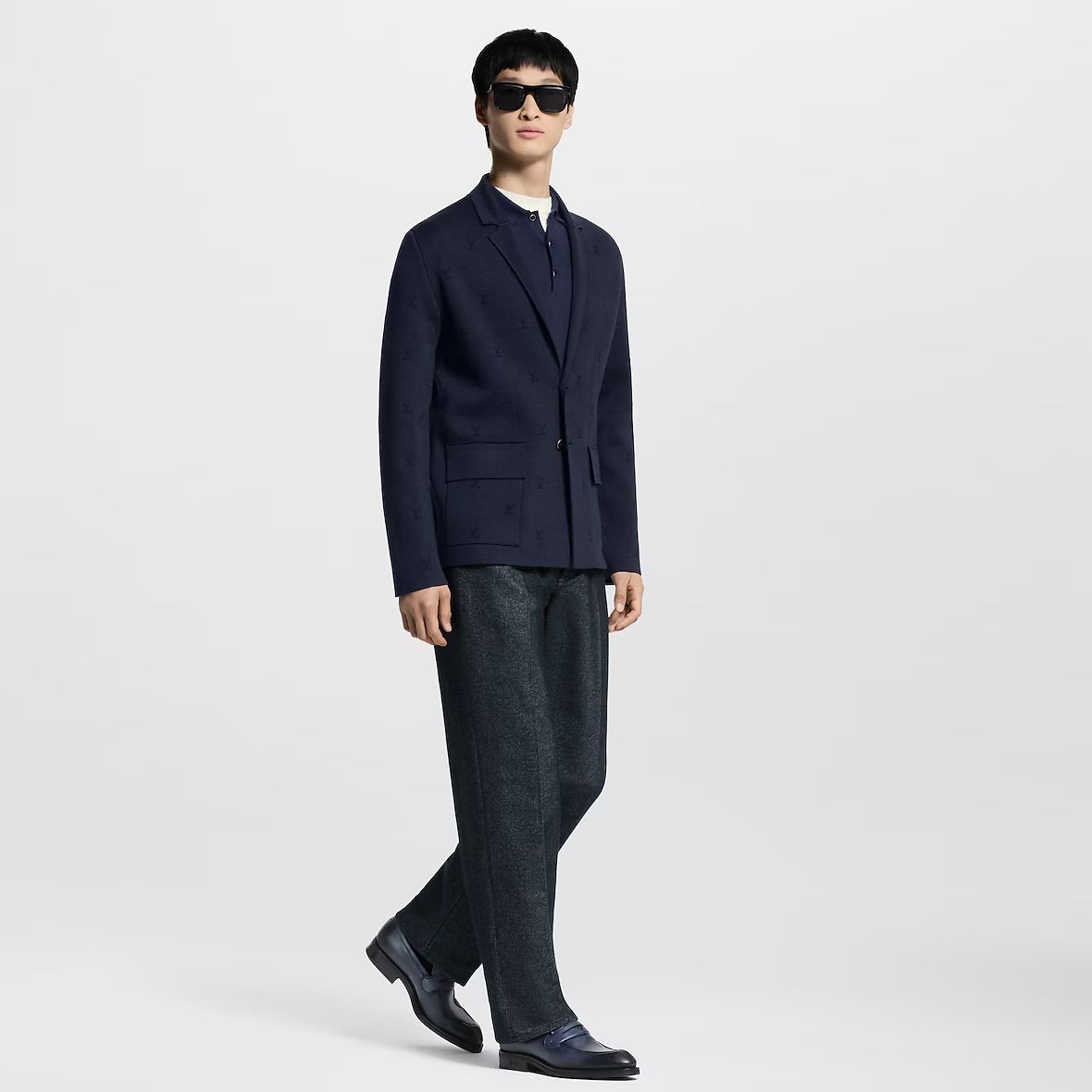 a man in a suit and sunglasses is standing