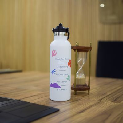 a white water bottle sitting on top of a wooden table