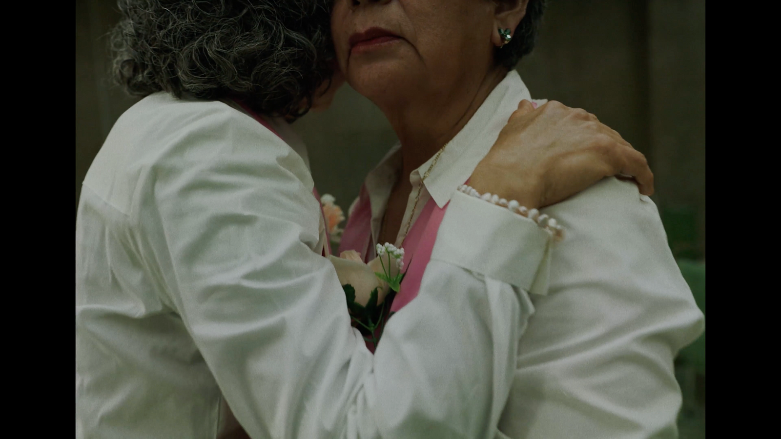 a woman hugging another woman with a flower in her lap