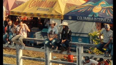 a group of people sitting on top of a wooden fence