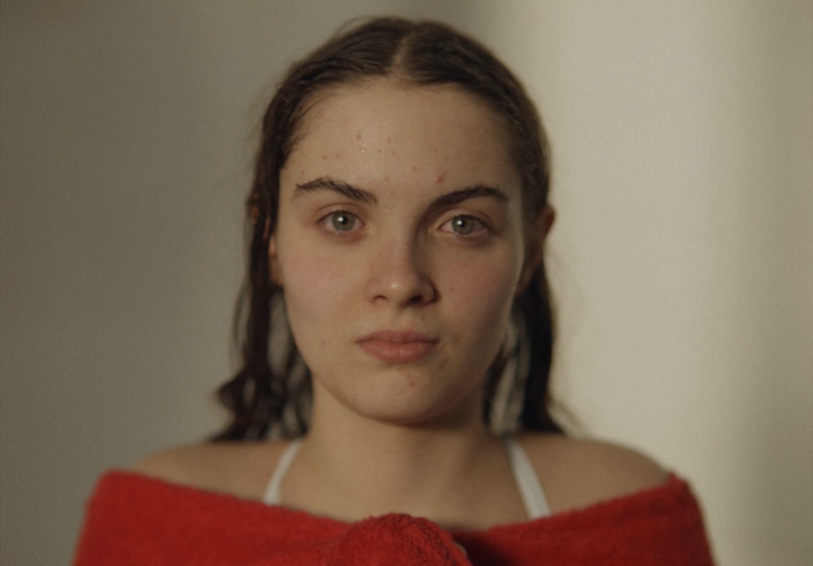 a woman in a red towel looking at the camera