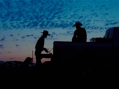 a couple of men standing next to a truck