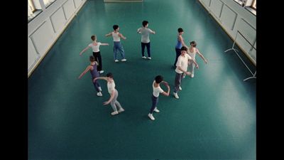 a group of people standing on top of a green floor