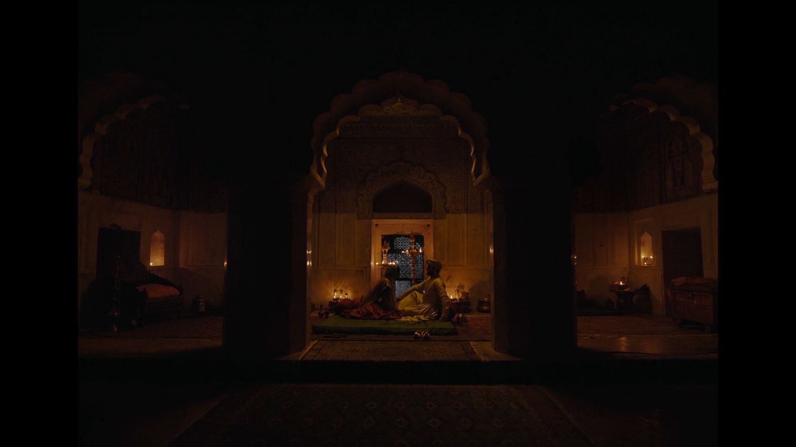 a person sitting on a rug in a dimly lit room