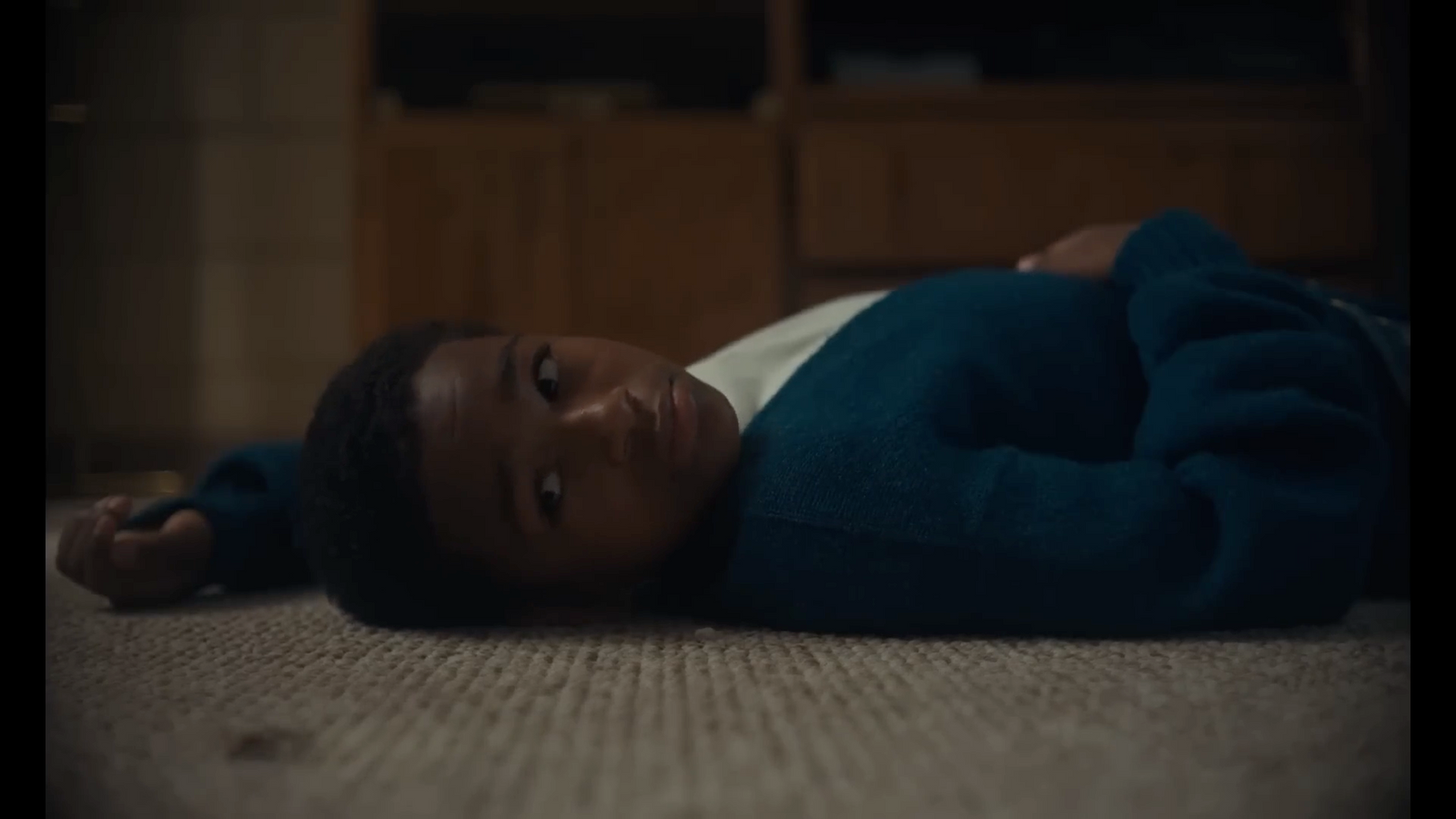 a young child laying on the floor in a living room