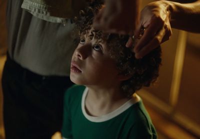 a little boy getting his hair cut by an adult