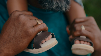 a close up of a person's hand holding a sandal