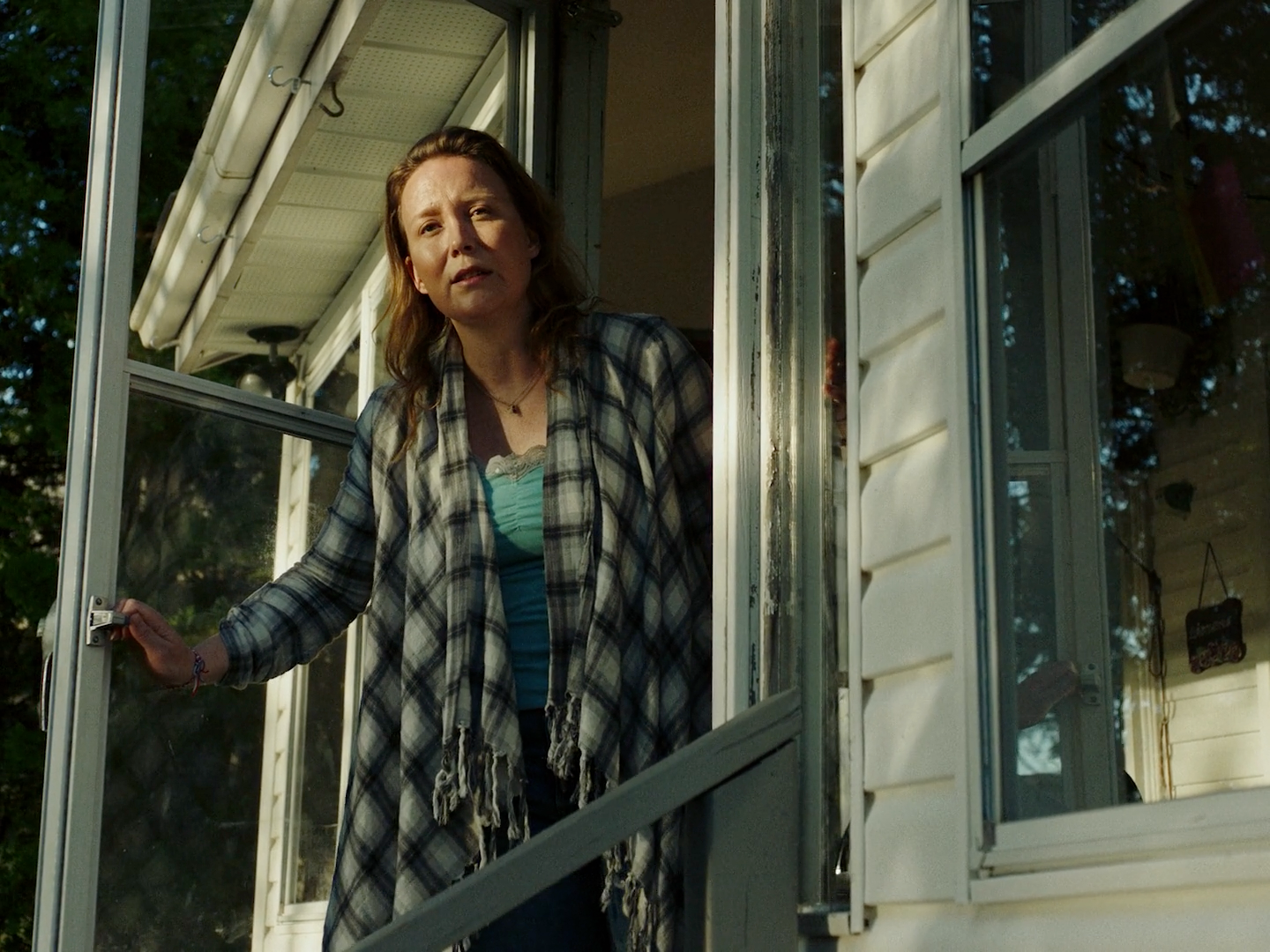 a woman standing on the porch of a house