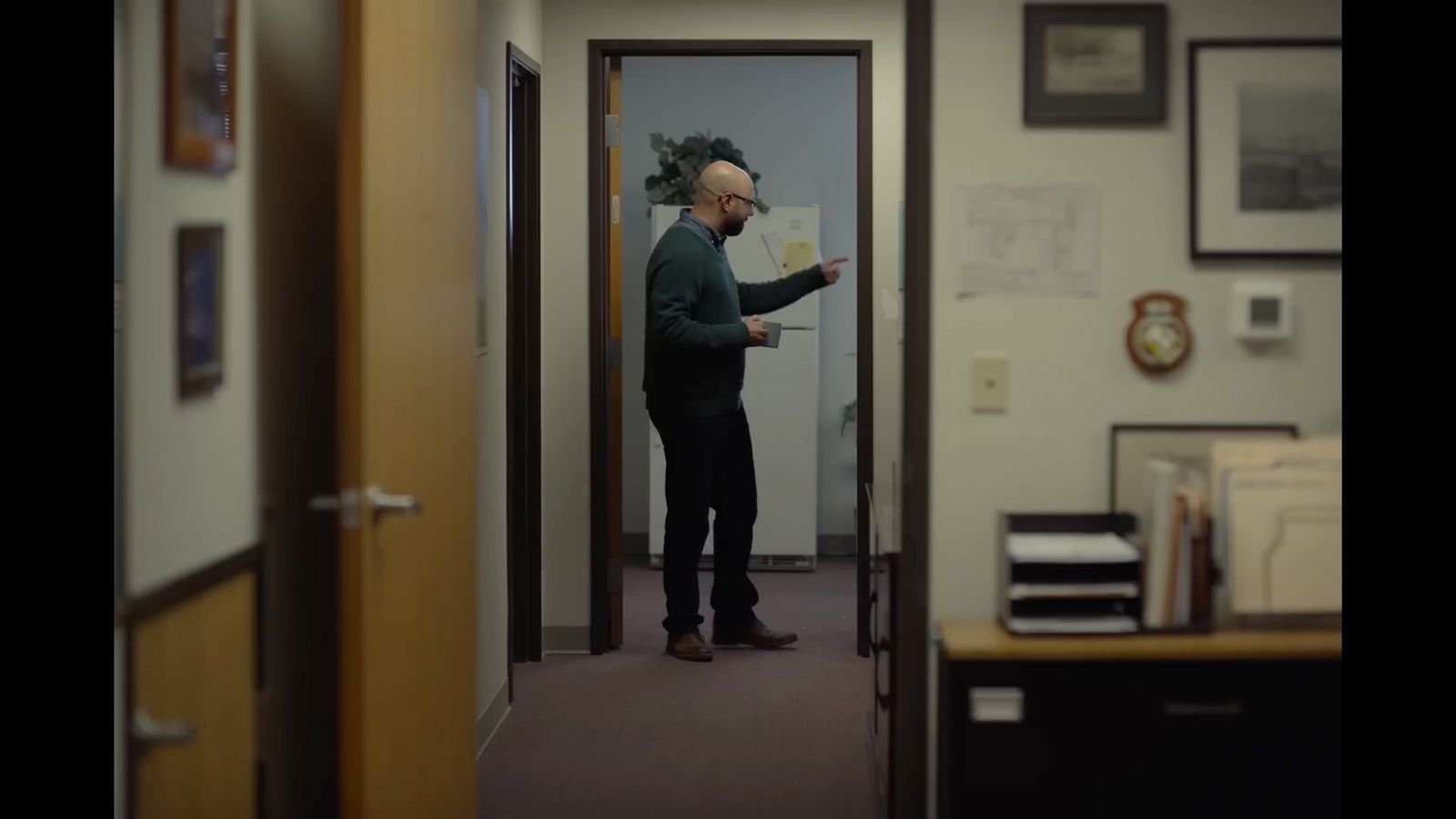 a man standing in a hallway next to a door