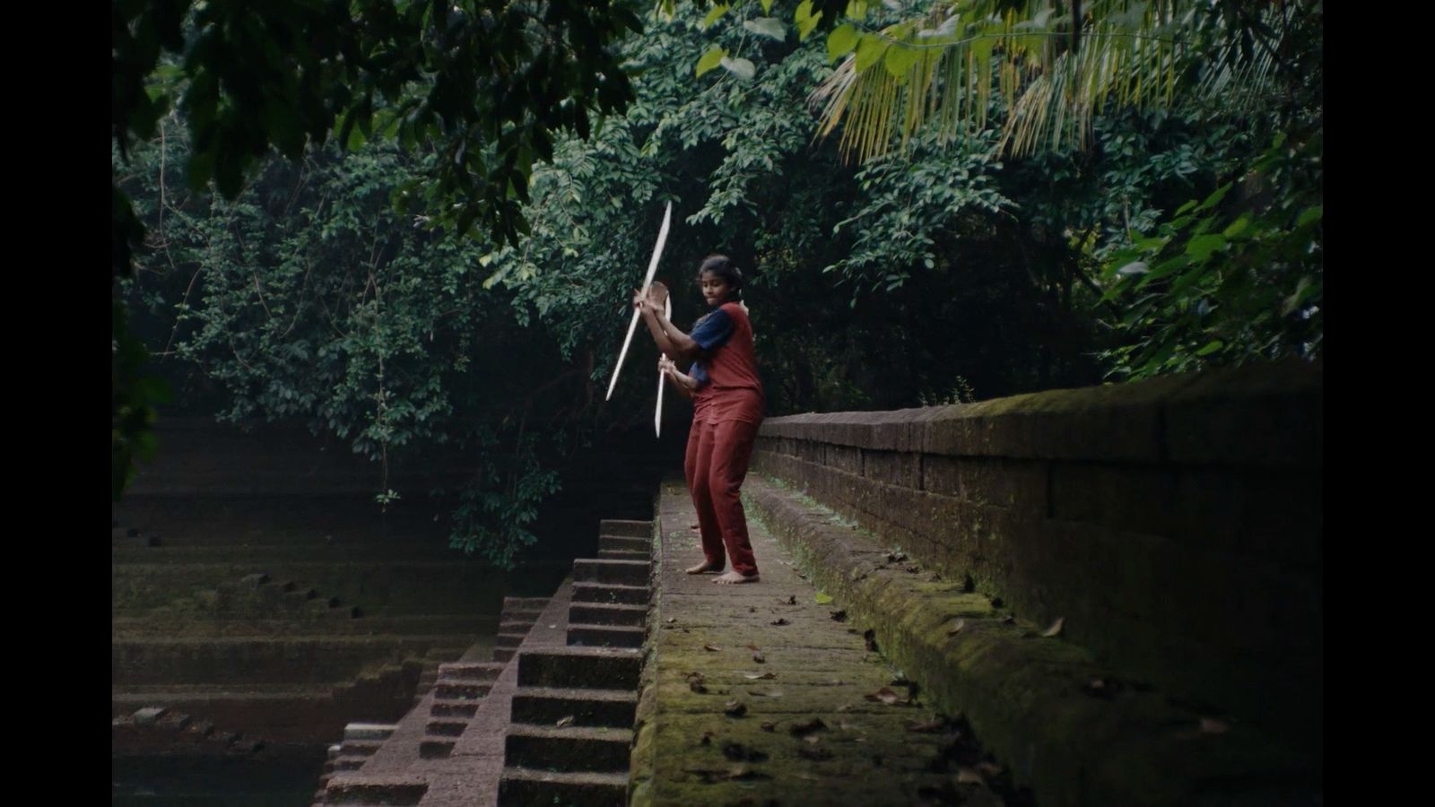 a man in a red jumpsuit holding an umbrella