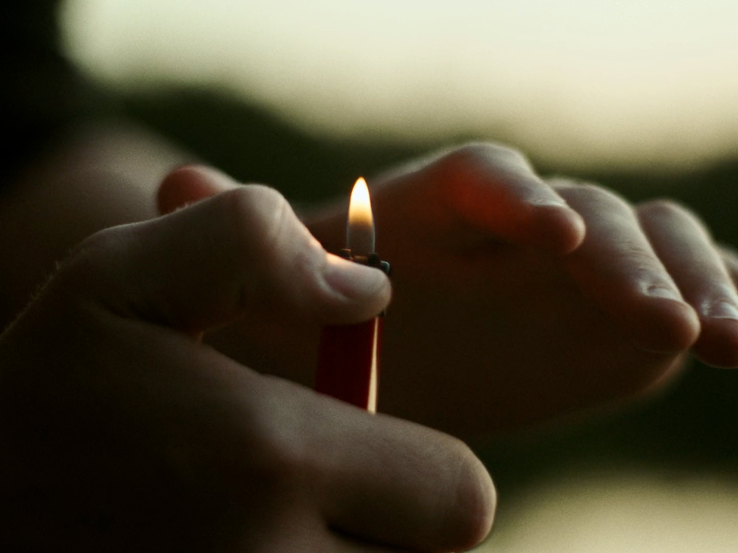 a person holding a lit candle in their hands