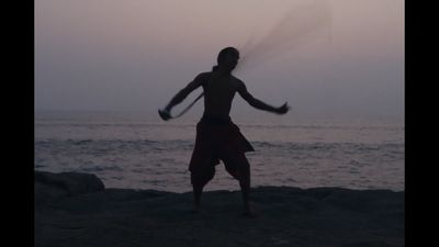 a man standing on top of a beach holding a racquet