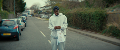 a man standing on the side of a road looking at his cell phone