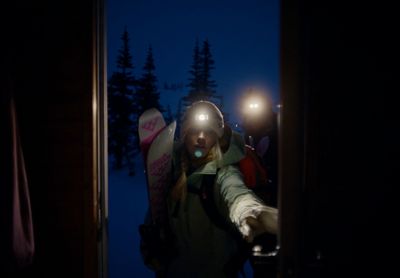 a person holding a snowboard in the dark