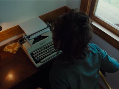 a person sitting at a desk with a typewriter