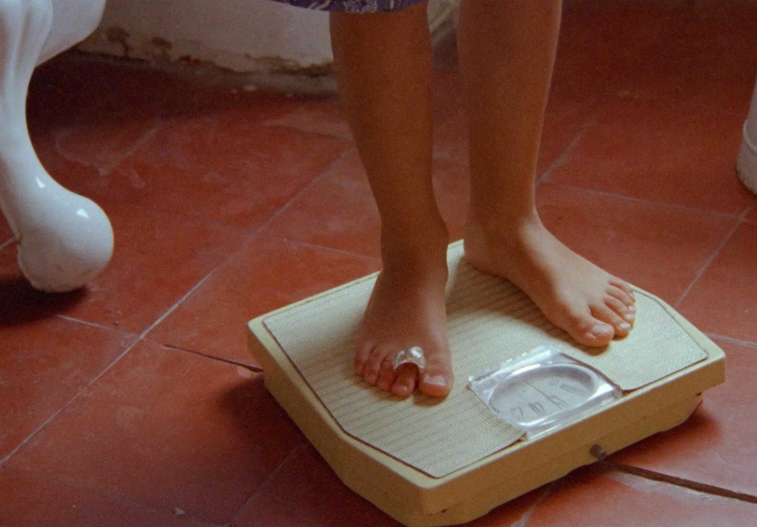 a person standing on a scale on a bathroom floor