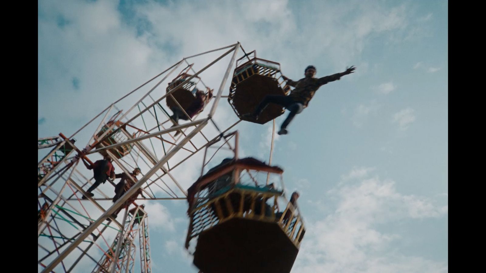 a man is on the top of a ferris wheel