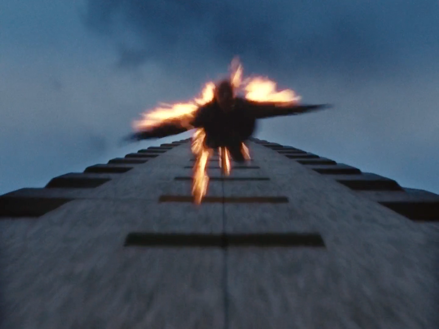 a bird flying over a tall building on a cloudy day