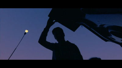 a silhouette of a man holding a street light