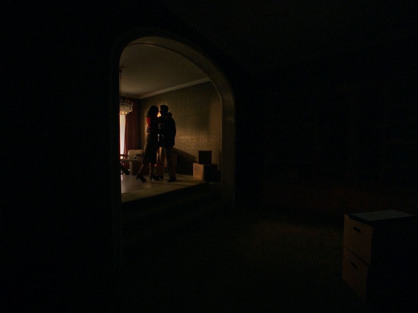 a man and woman standing in a dark room