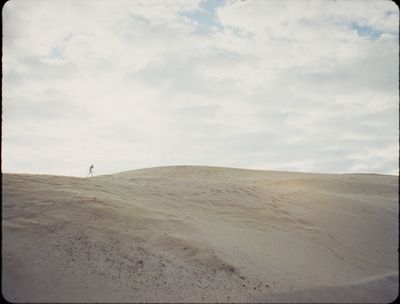 a person standing on top of a sandy hill