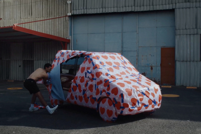 a man pushing a car wrapped in a polka dot pattern