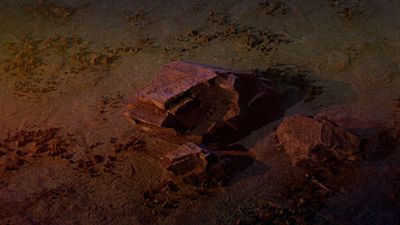 a pile of rocks sitting on top of a sandy beach