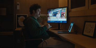 a man sitting in front of a computer monitor