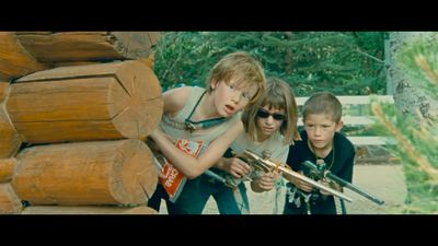 a group of children holding guns in front of a pile of logs