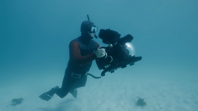 a man in a diving suit holding a camera