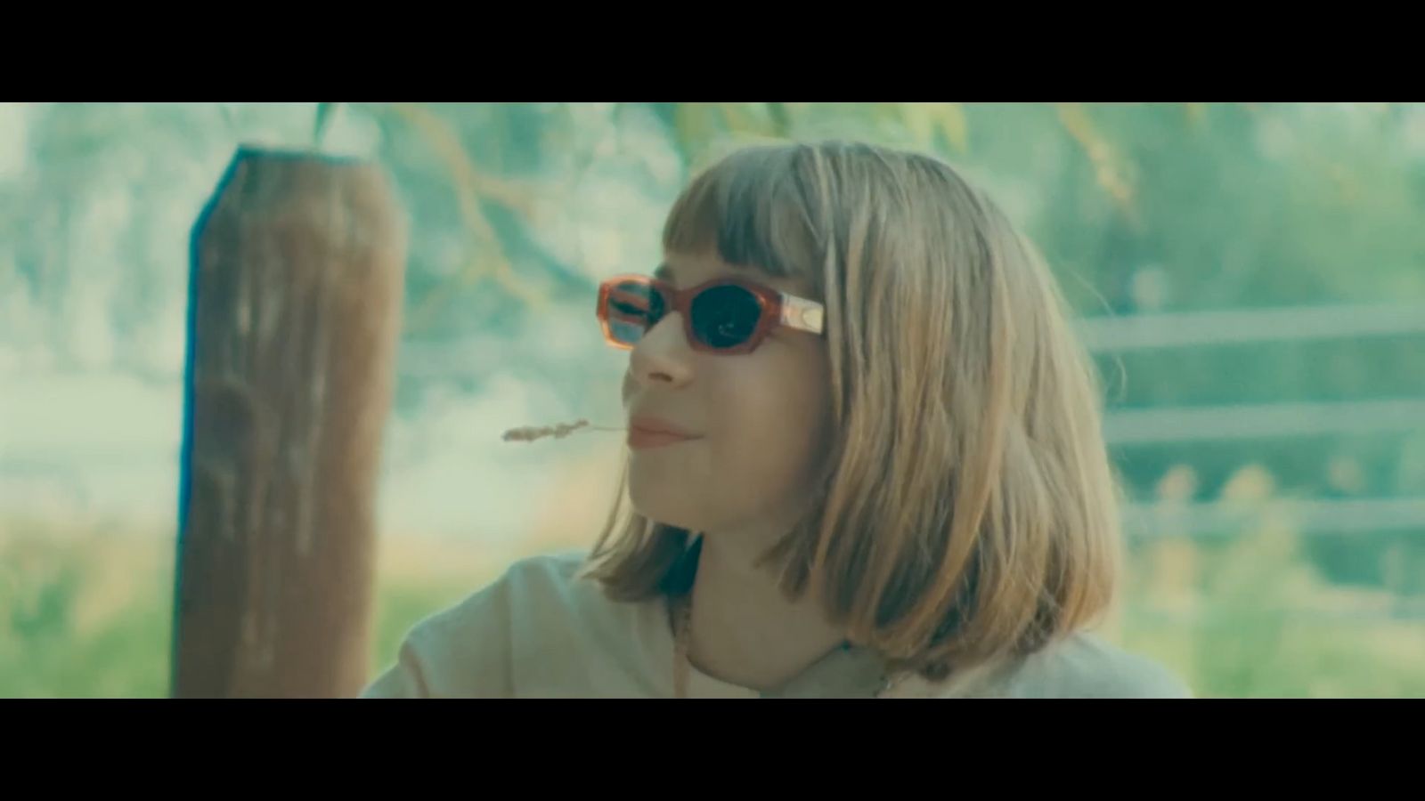 a woman wearing sunglasses smoking a cigarette