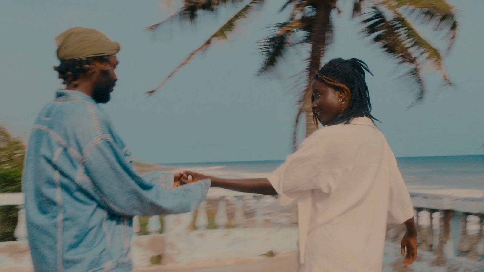 a man and a woman standing next to each other on a beach