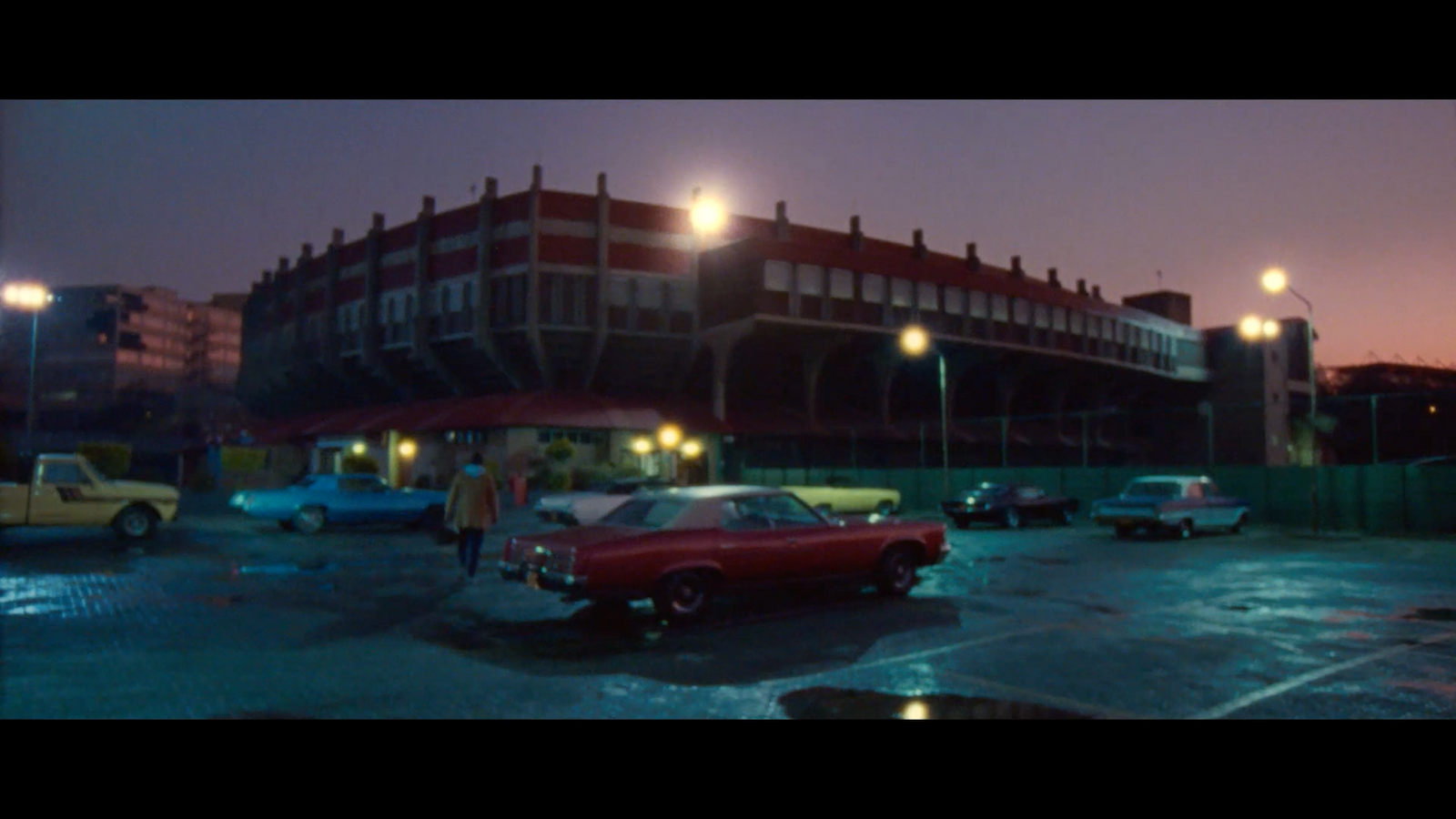 a red car parked in a parking lot next to a building