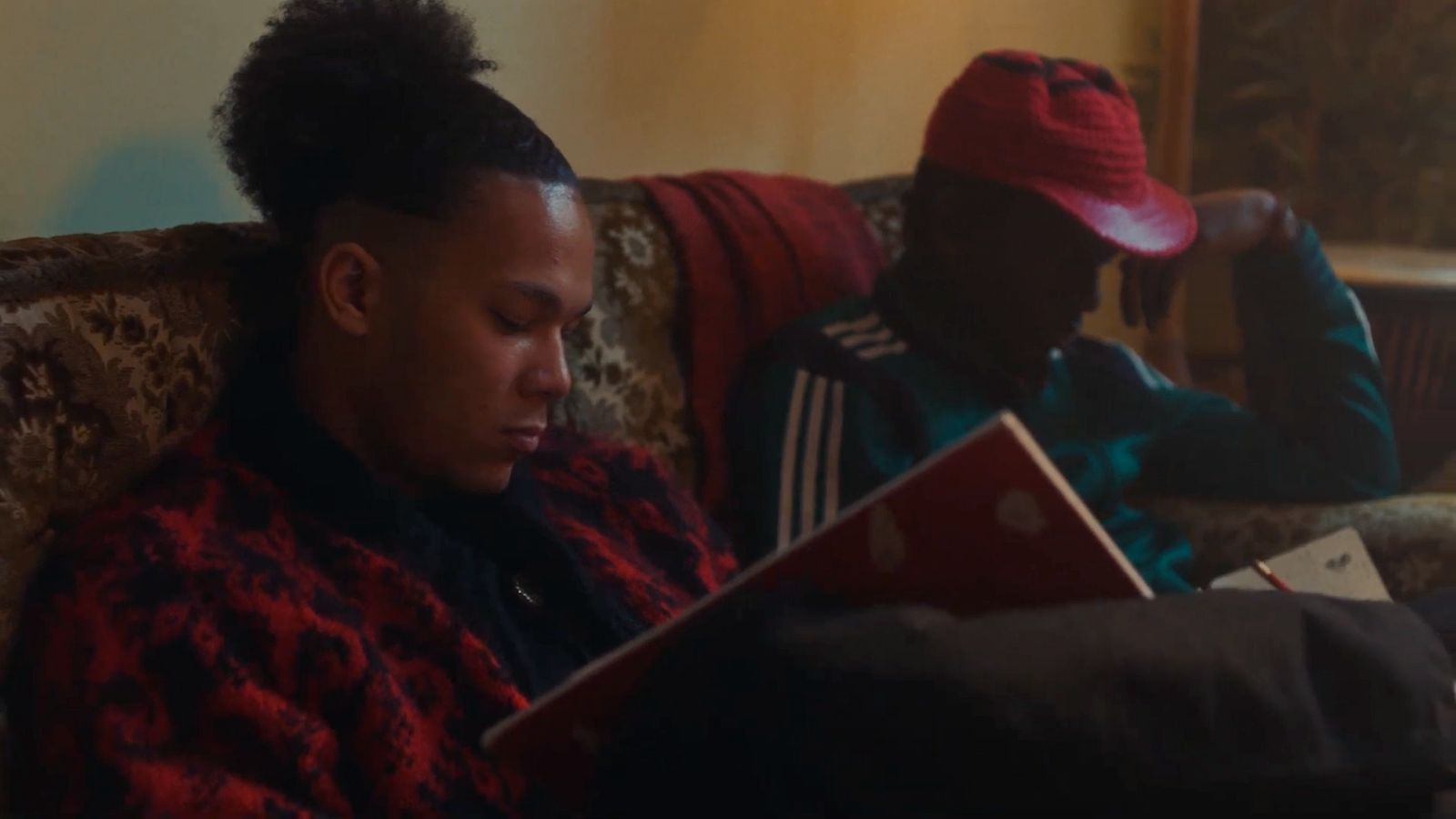 a man sitting on a couch looking at a book