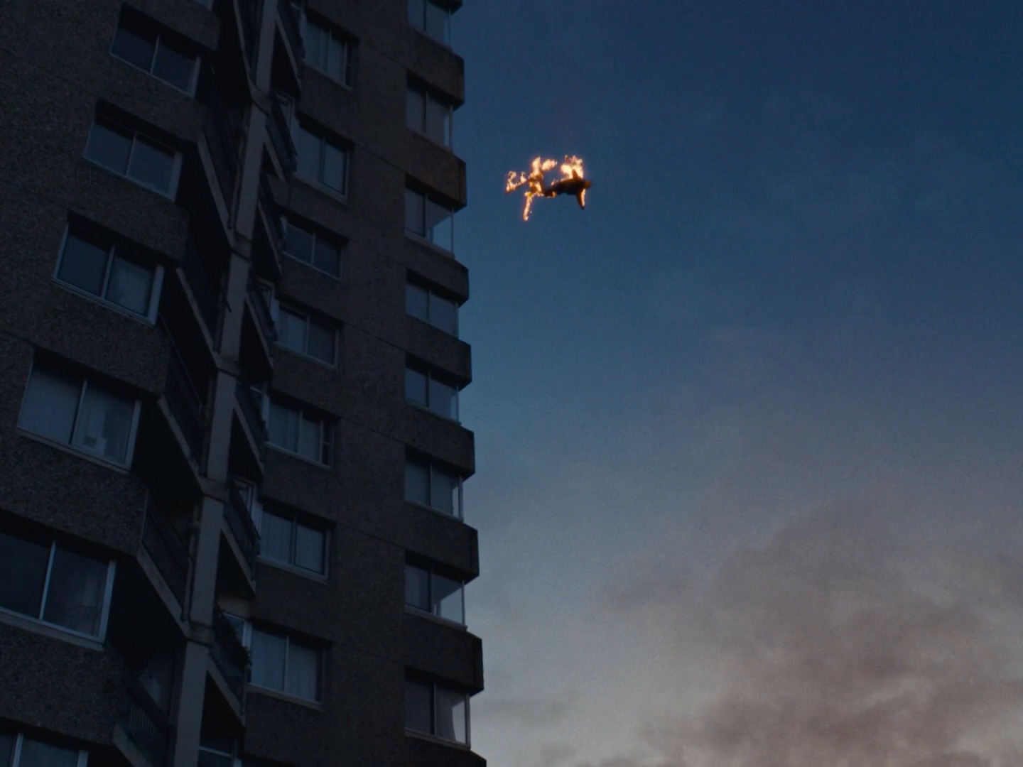 a plane flying in the sky over a tall building