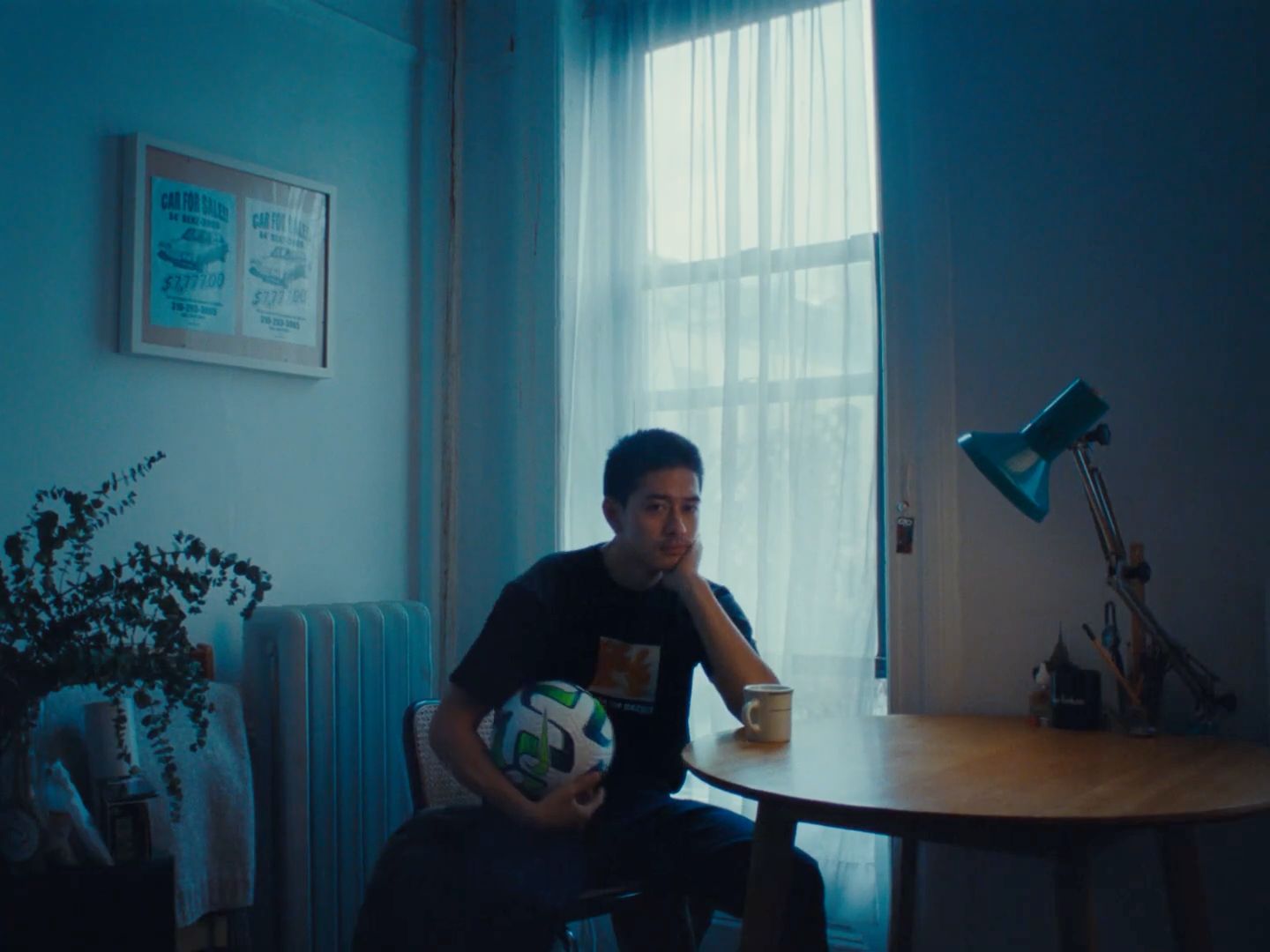 a man sitting at a table with a soccer ball