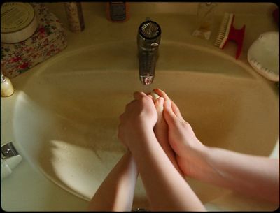 a person is sitting in a sink with their feet in the sink