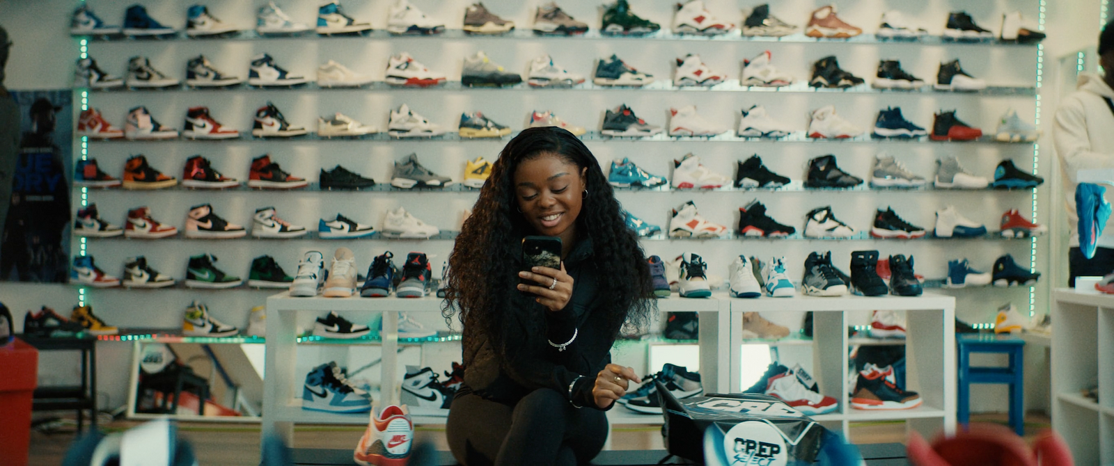 a woman is looking at her cell phone in a shoe store