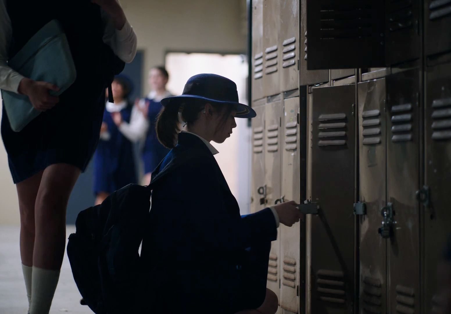 a woman sitting on the ground in front of lockers