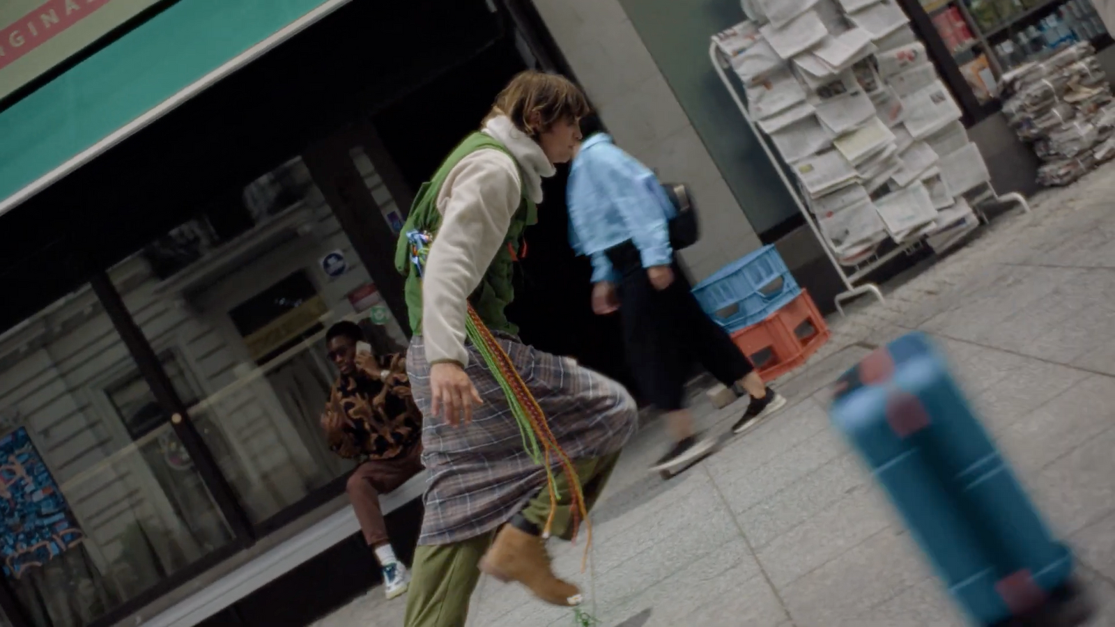 a woman walking down a street past a store