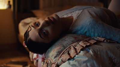 a young girl laying on a bed looking up