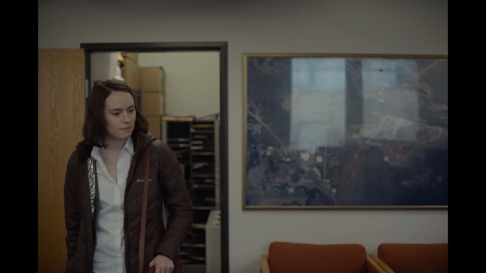 a woman standing in a living room next to a couch