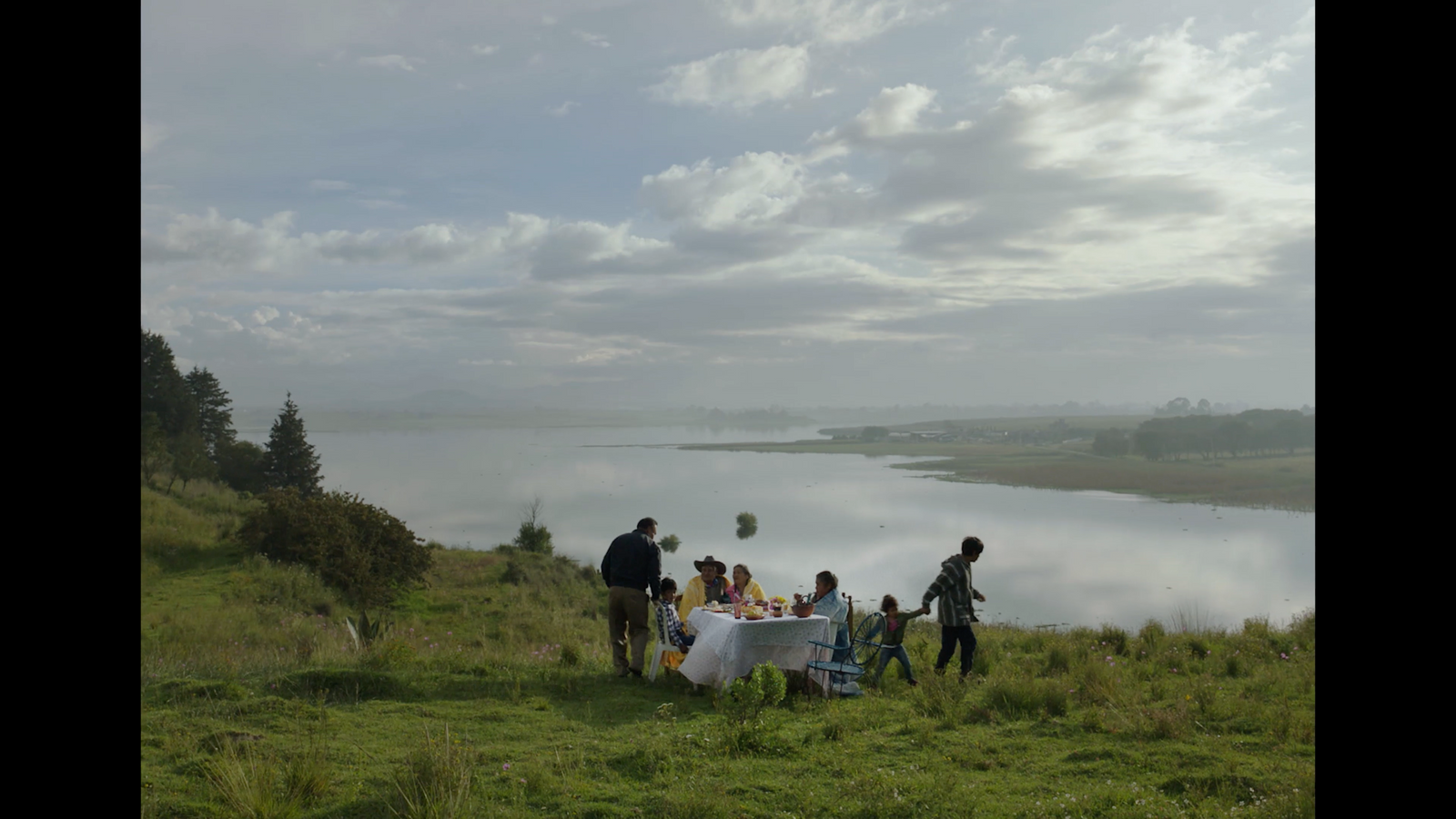 a group of people standing on top of a lush green hillside