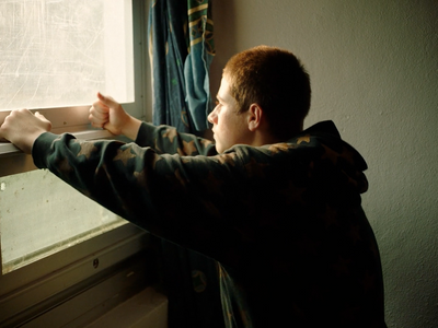 a man is looking out of a window