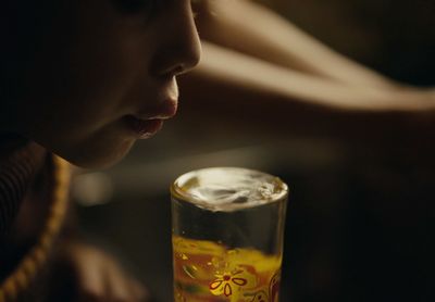 a close up of a person with a drink in a glass