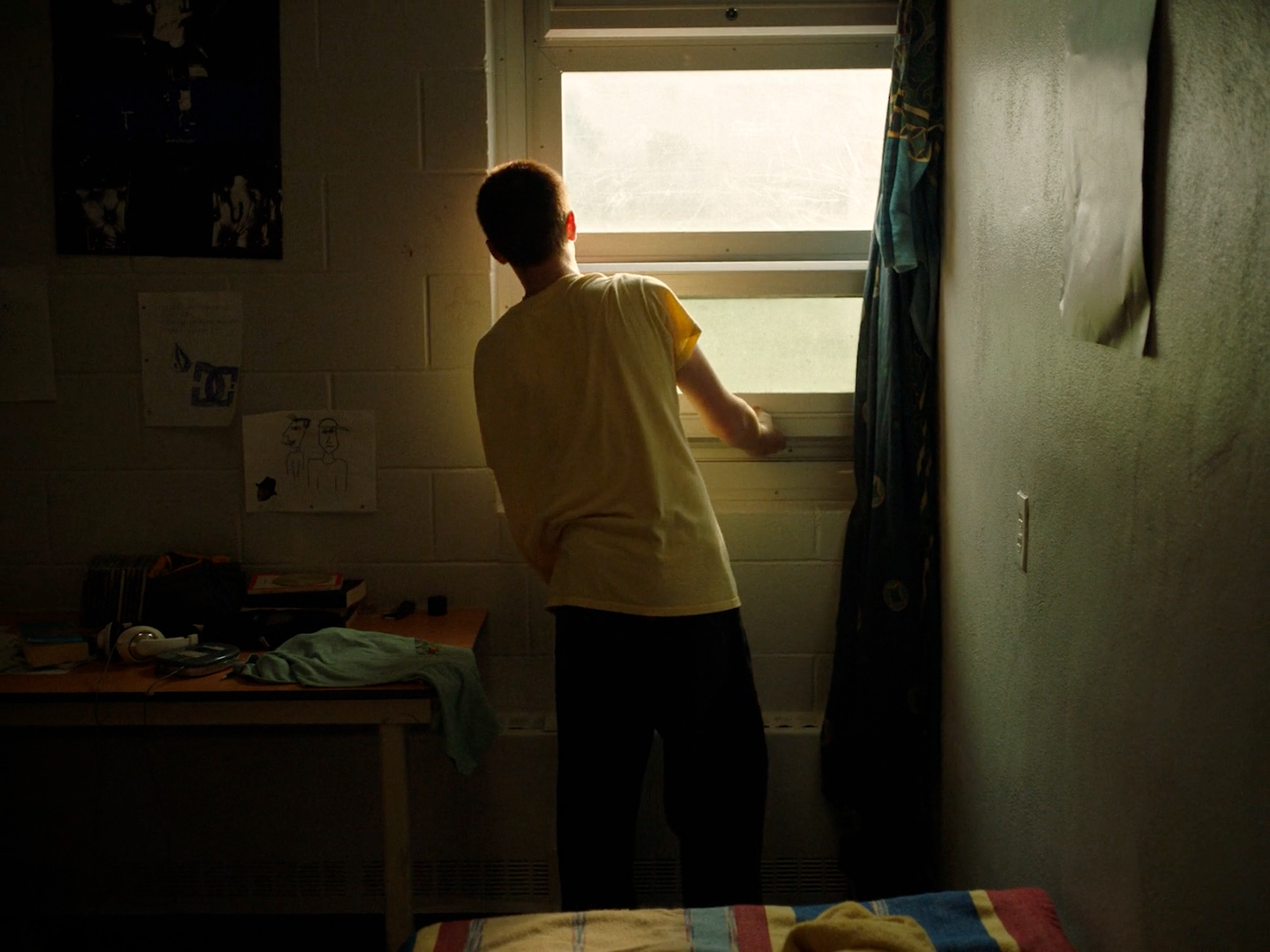 a man standing in front of a window in a bedroom